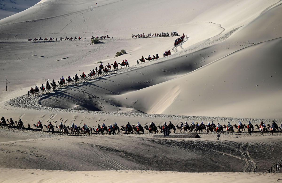 XINHUA PHOTO OF THE DAY: Camel Rides at Mingsha Mountain in Dunhuang